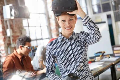 Portrait smiling female computer programmer wearing virtual reality simulator Foto stock