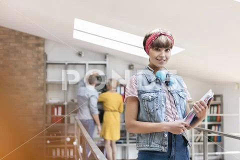 Portrait smiling female design professional with headphones in office Stock Photos