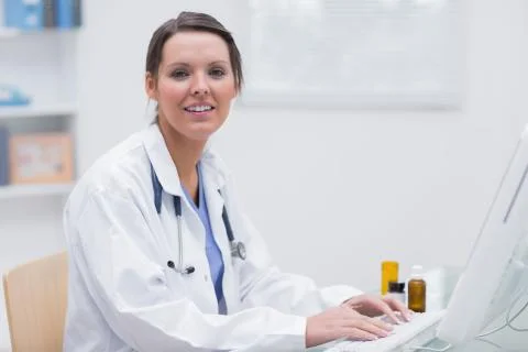 Portrait of smiling female doctor using computer Stock Photos