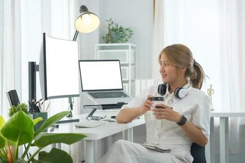 Portrait of smiling female IT developer sitting front of large curved compu.. Stock Photos