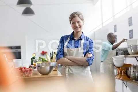 Portrait smiling female student in cooking class kitchen Stock Photos