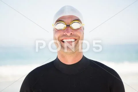 Portrait of smiling fit swimmer on the beach Stock Photos