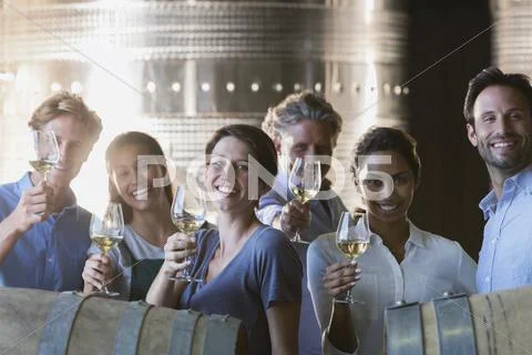 Portrait smiling friends wine tasting in winery cellar Stock Photos