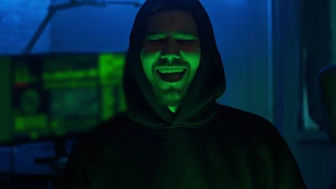 Portrait of a smiling hacker, standing in front of his computer equipment in his Stock Footage 279022443