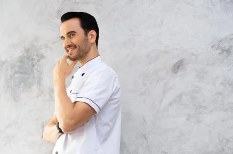 Portrait of smiling handsome chef posing against with beard looking to side. Stock Photos