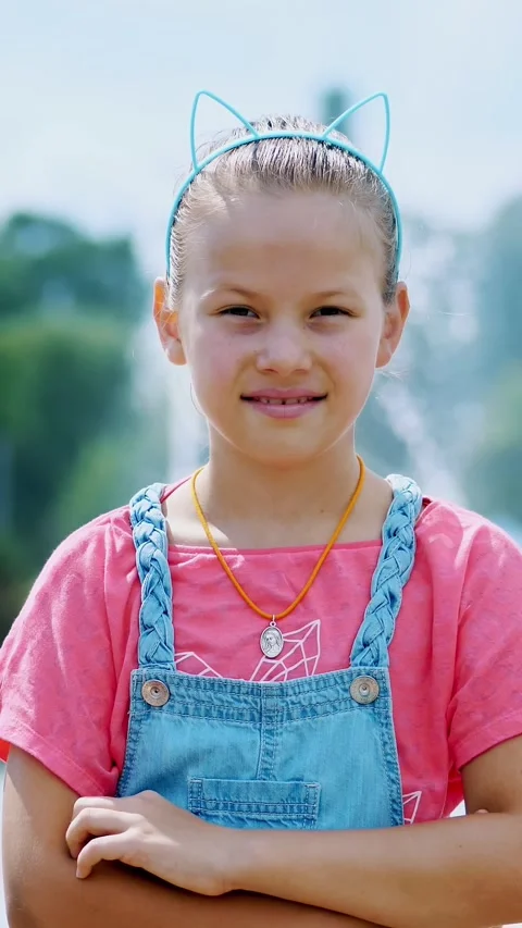 Portrait of a smiling, happy eight-year-old girl in a fun hoop with ears on her Stock Footage 315564721