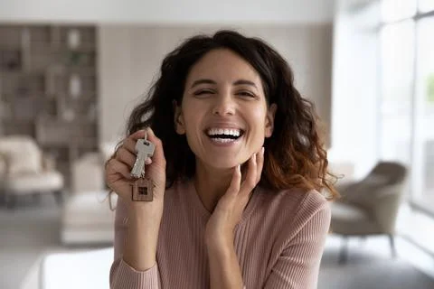Portrait of smiling Latin woman show keys to new home Stock Photos