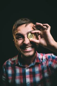 Portrait of smiling man with bitcoin instead of eye Stock Photos
