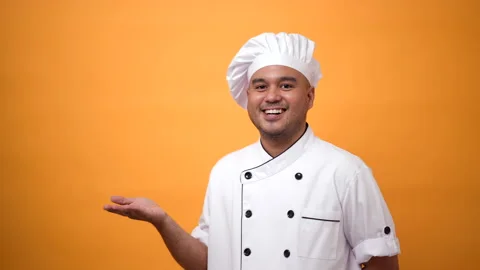 Portrait of smiling man chef standing and palm up hand on isolated yellow. Stock Footage 172283714