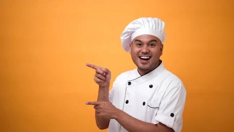 Portrait of smiling man chef standing and pointing finger on isolated yellow. Stock Footage 172283719