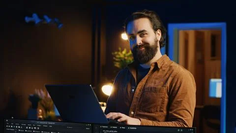Portrait of smiling man doing IT support job from home, standing in office 库存照片