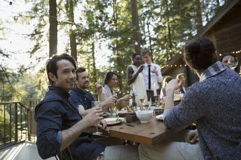 Portrait smiling man drinking at dining table on balcony at wedding reception Stock Photos