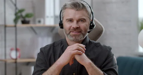 Portrait of smiling Man in Headset looking intently at Camera in Office Room Stock Footage 152398903