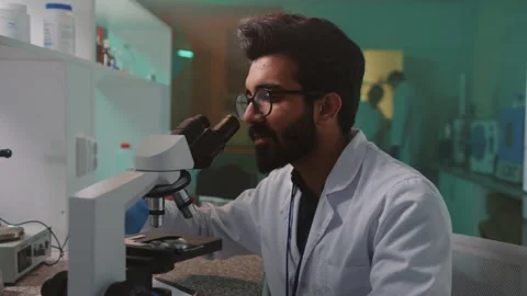Portrait smiling man scientist with glasses and protective gloves looking in the Stock Footage 252138212