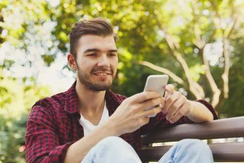 Portrait of smiling man using smartphone outdoors Foto stock