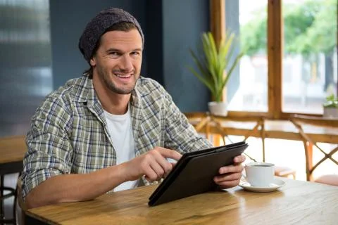 Portrait of smiling man using tablet computer in coffee shop Stock Photos