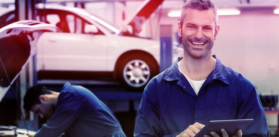 Portrait of smiling mechanic using tablet pc 스톡 사진