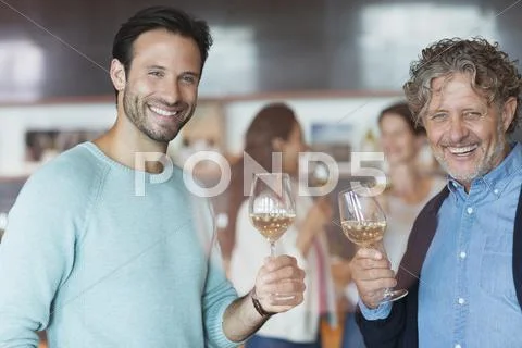 Portrait smiling men wine tasting at winery tasting room Stock Photos