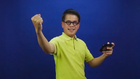 Portrait of smiling middle-aged asian man in yellow T shirt feeling excited Stock Footage 219190099