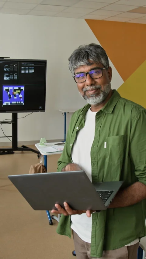 Portrait of Smiling Middle Aged Indian Man Holding Laptop in Tech Lab Stock Footage 342823845