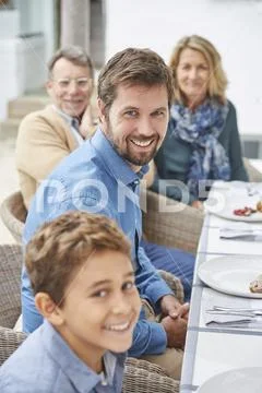 Portrait smiling multi-generation family enjoying patio lunch Stock Photos