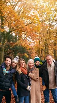 Portrait Of Smiling Multi-Generation Family Walking Along Autumn Woodland Path Stock Photos