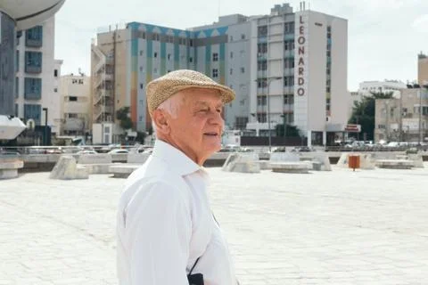 Portrait of a smiling old man in a flat cap walking in Tel Aviv, Israel Stock Photos