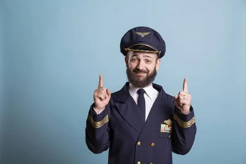 Portrait of smiling pilot points up with both index fingers 写真素材