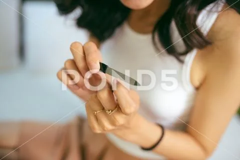 Portrait of a smiling pretty young woman painting friend's nails over white b Stock Photos