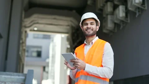 Portrait of smiling professional engineer wearing safety helme, vest standing  Stock Footage 314719988