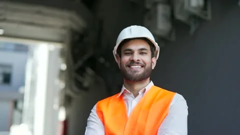 Portrait of smiling professional engineer wearing safety helmet and vest standin Stock Footage 329858268