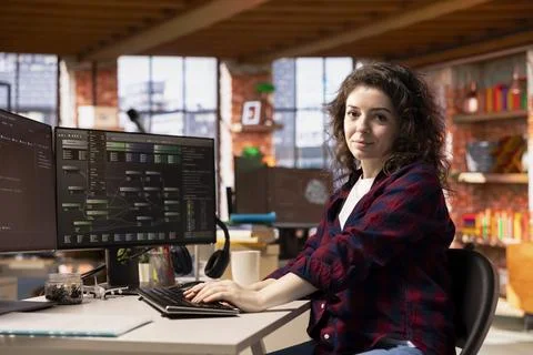 Portrait of smiling programmer using coding platform in Silicon Valley office Stock-Fotos