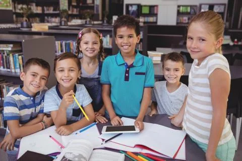 Portrait of smiling schoolkid using digital tablet in library 스톡 사진