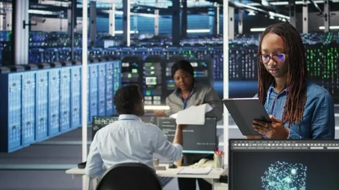 Portrait of smiling server room engineer using device to interpret AI data Stock Footage 309117655