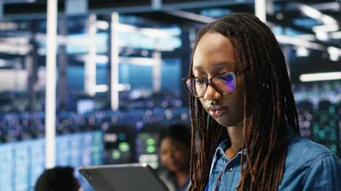 Portrait of smiling server room engineer using device to interpret AI data Stock Footage 309506741