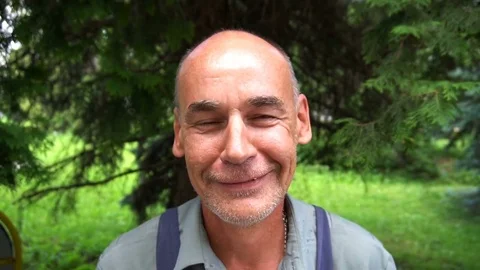 Portrait of a smiling shoemaker on a background of green pine needles Stock Footage 77883498