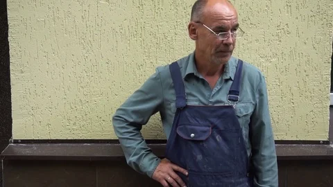 Portrait of a smiling shoemaker in glasses standing against the yellow wall Stock Footage 77921615