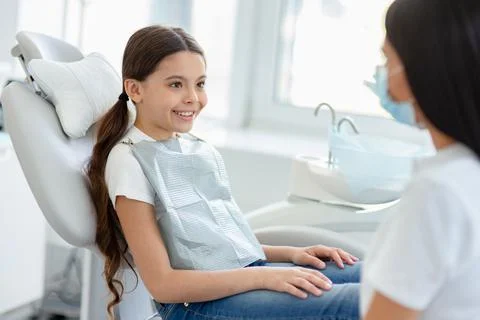 Portrait of smiling small client and female dentist in dental office Stock Photos