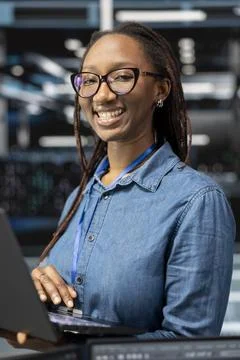 Portrait of smiling technician in data center monitoring system performance Stock Photos