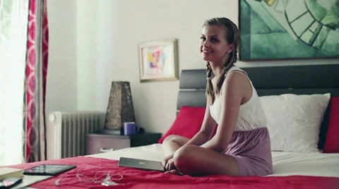 Portrait of smiling teenage girl with laptop computer sitting in her bedroom Stock Footage