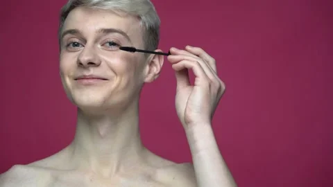 Portrait of smiling topless transgender doing make up with eyelash mascara 库存影片 156608685