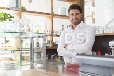 Portrait smiling waiter behind the counter in cafe Stock Photos
