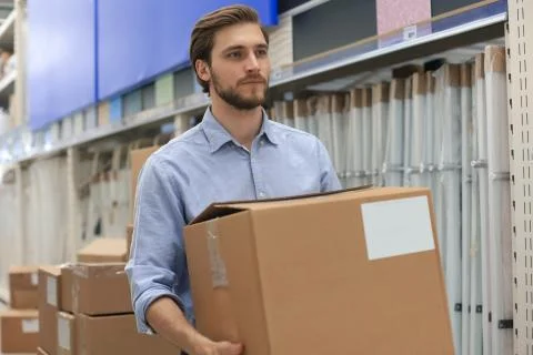 Portrait of a smiling warehouse keeper at work. Stock Photos