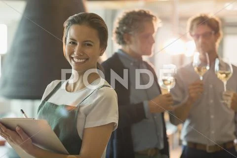 Portrait smiling woman with clipboard working in wine tasting room Stock Photos