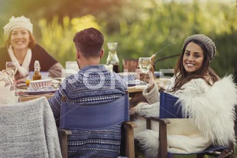 Portrait smiling woman drinking wine at garden lunch table Stock Photos