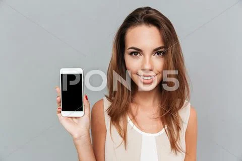 Portrait of a smiling woman showing blank smartphone screen Stock Photos