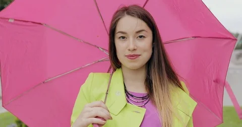 Portrait of smiling woman under umbrella in city at overcast summer or autumn Stock Footage