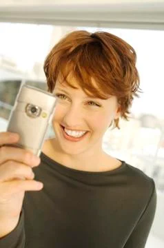 Portrait of a smiling woman using camera phone Stock Photos