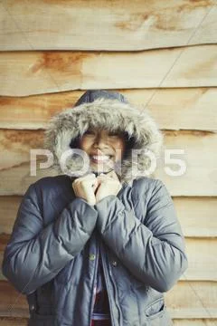 Portrait smiling woman wearing fur hood coat outside cabin Stock Photos