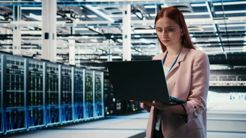 Portrait of smiling woman working in server farm doing network management Stock Footage 330028983